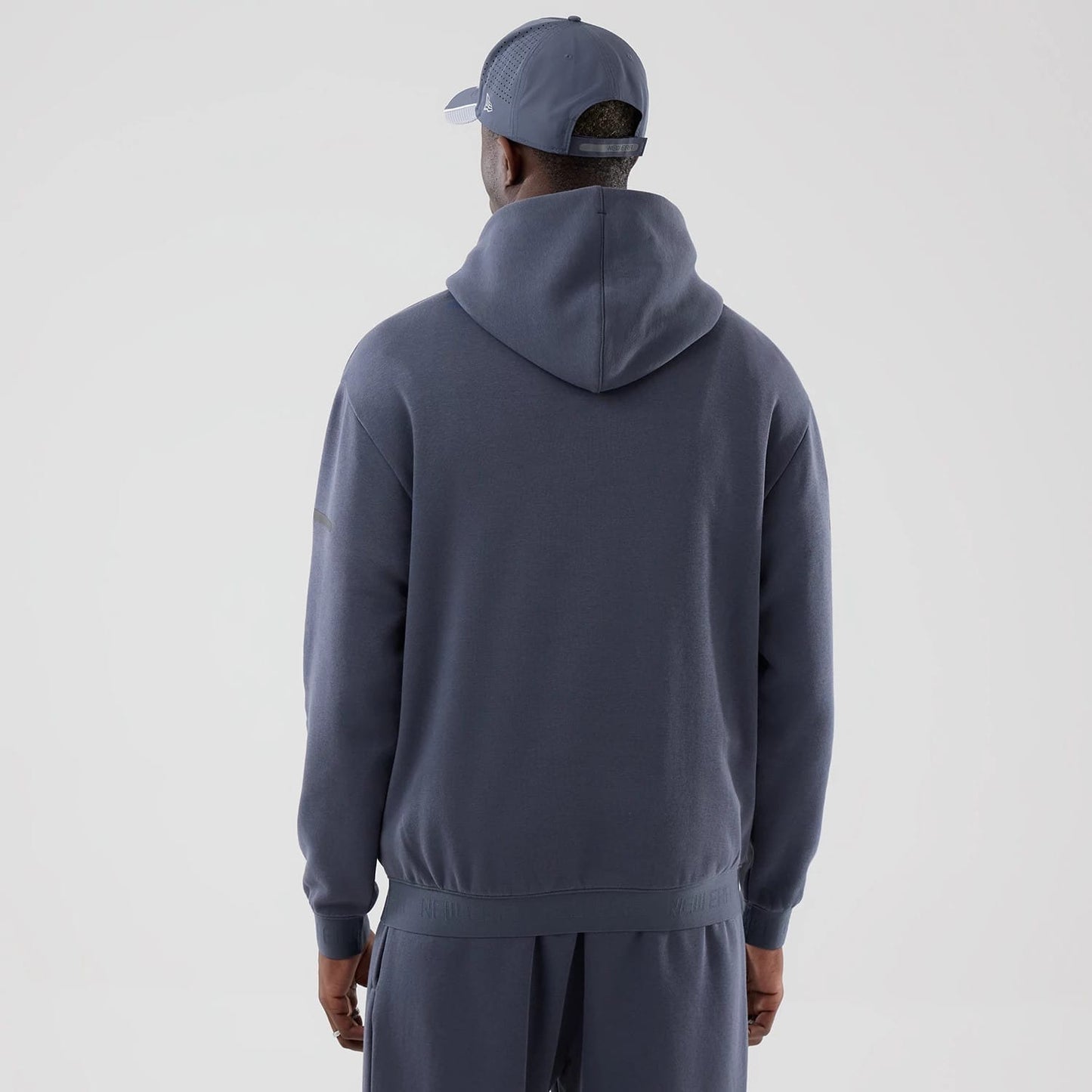 The model is wearing this New Era Tech Oversized Pullover Hoodie in grey. 2