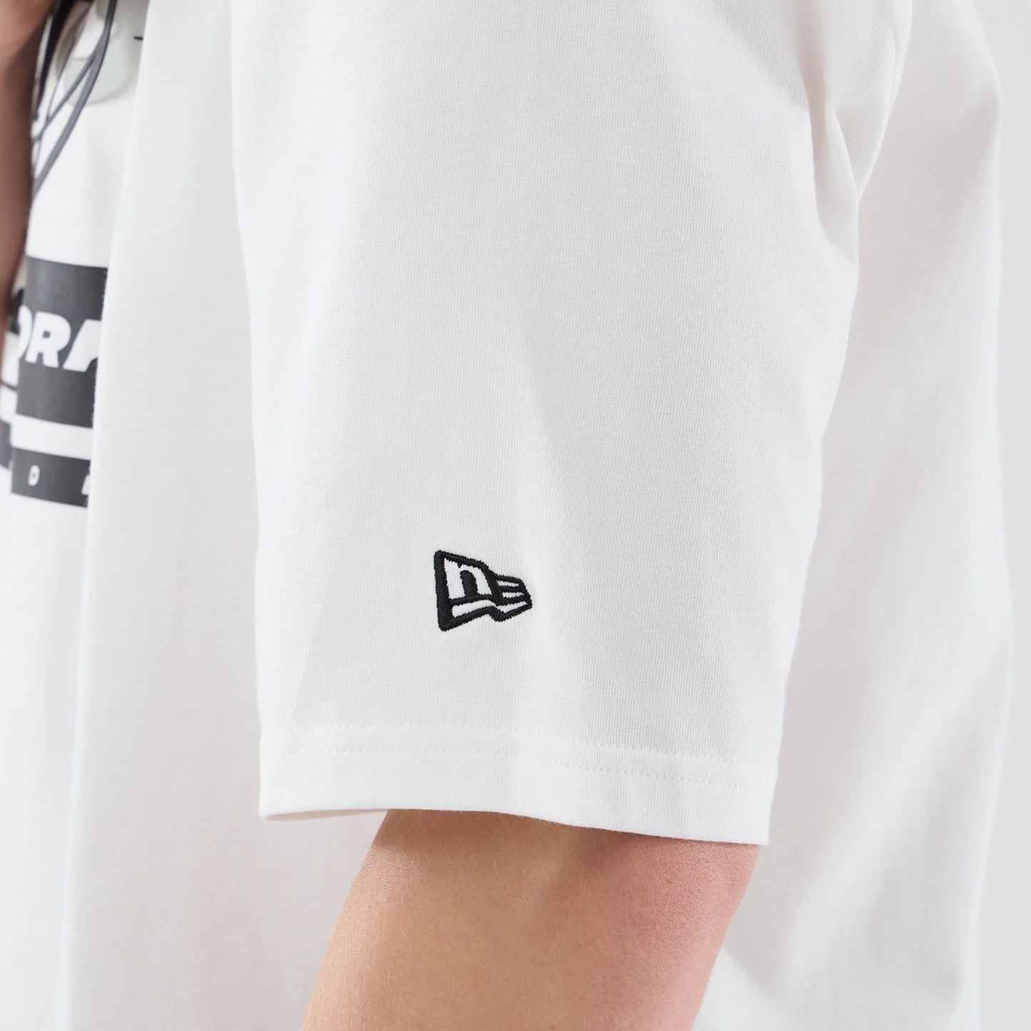 The model is wearing this MLB Logo Graphic New York Yankees Oversized T-Shirt in white. 5