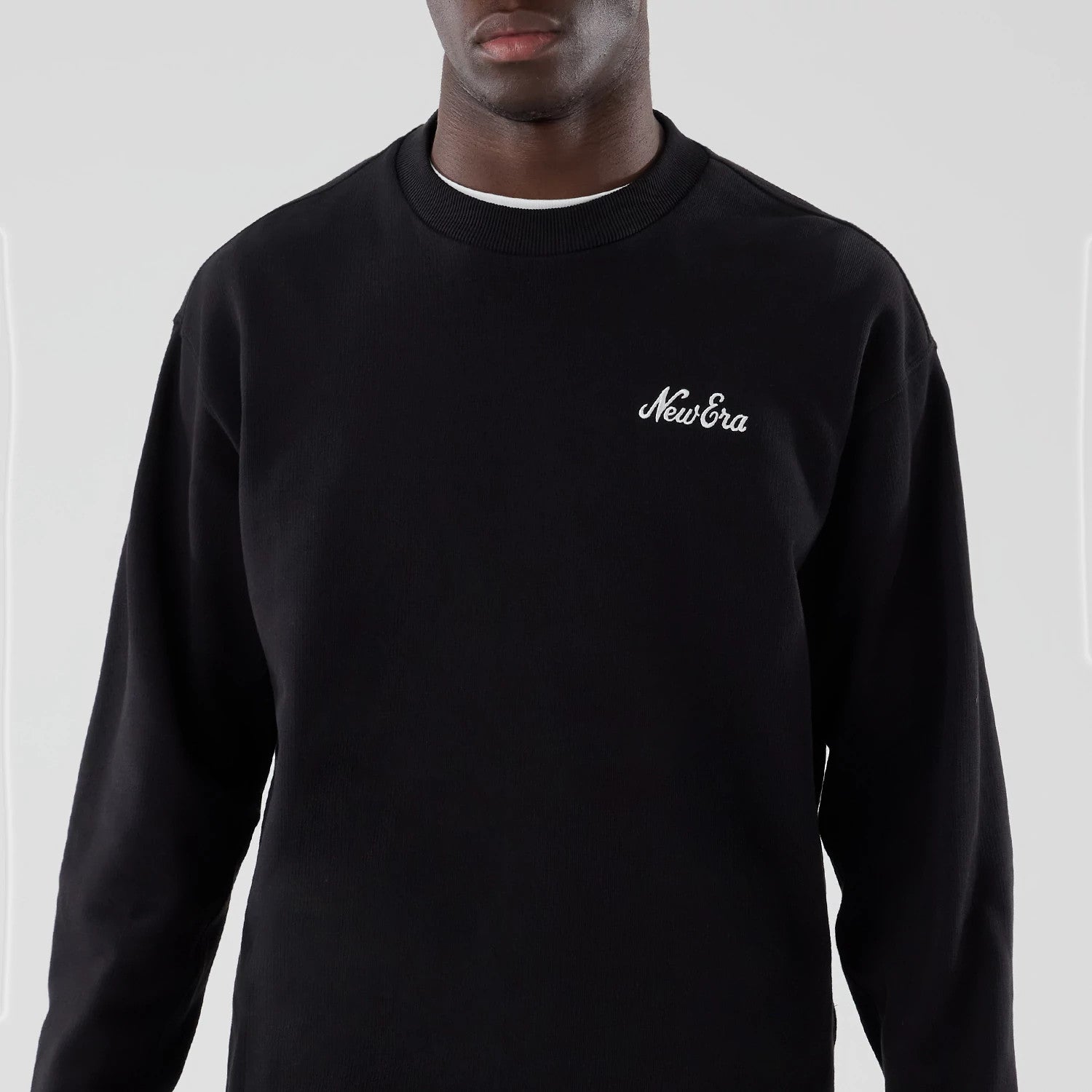 The model is wearing this New Era Oversized Crew Neck Sweater in black. 3
