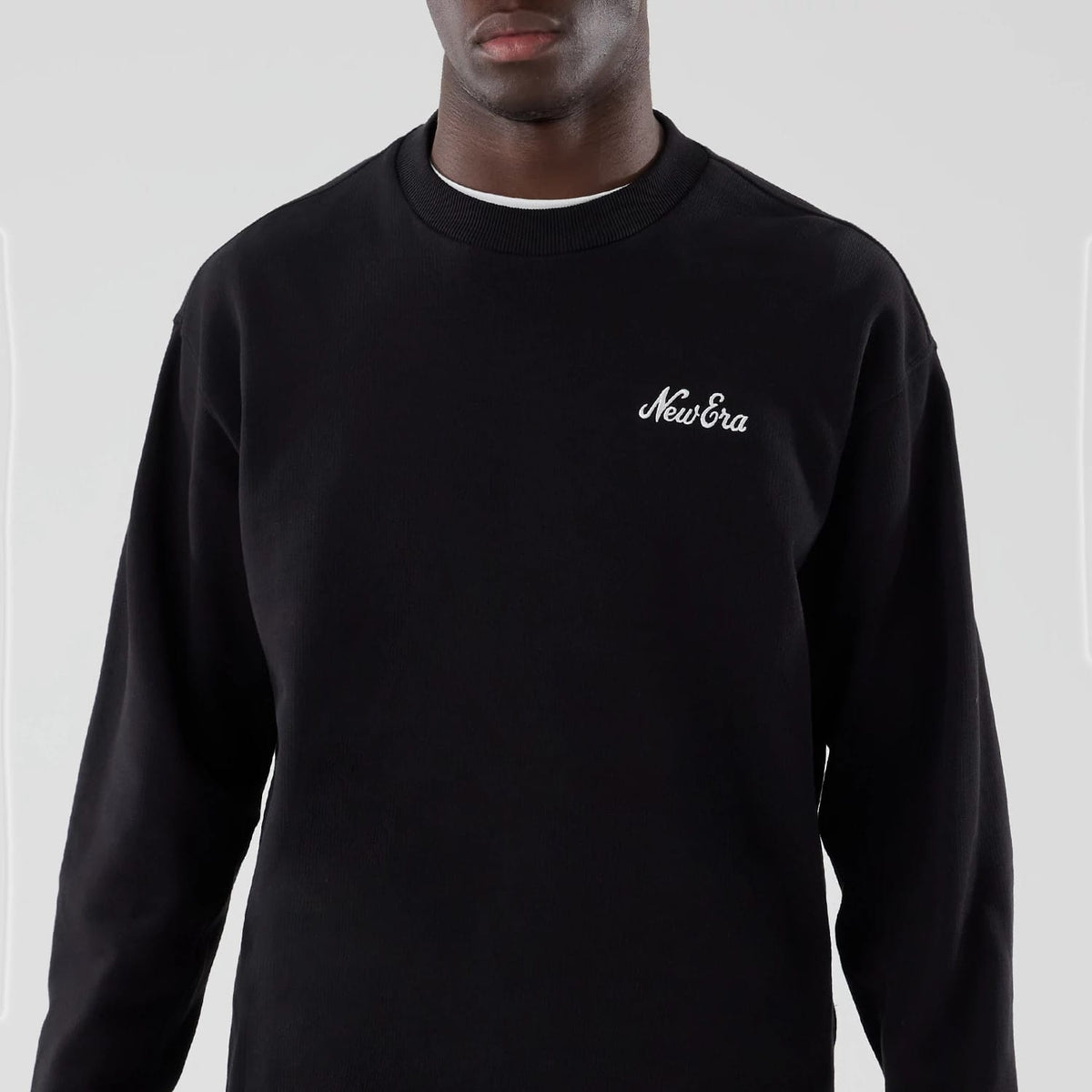 The model is wearing this New Era Oversized Crew Neck Sweater in black. 3