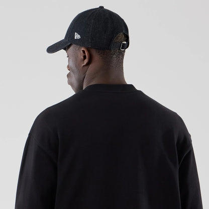 The model is wearing this New Era Oversized Crew Neck Sweater in black. 7