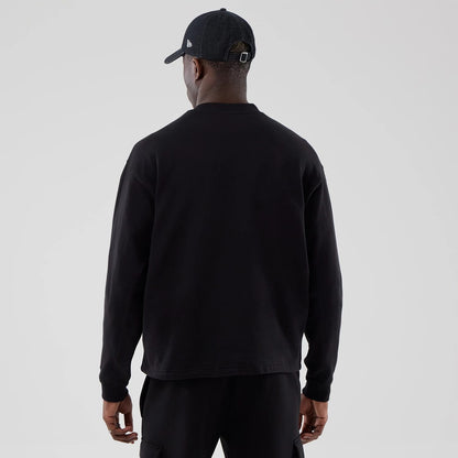 The model is wearing this New Era Oversized Crew Neck Sweater in black. 2