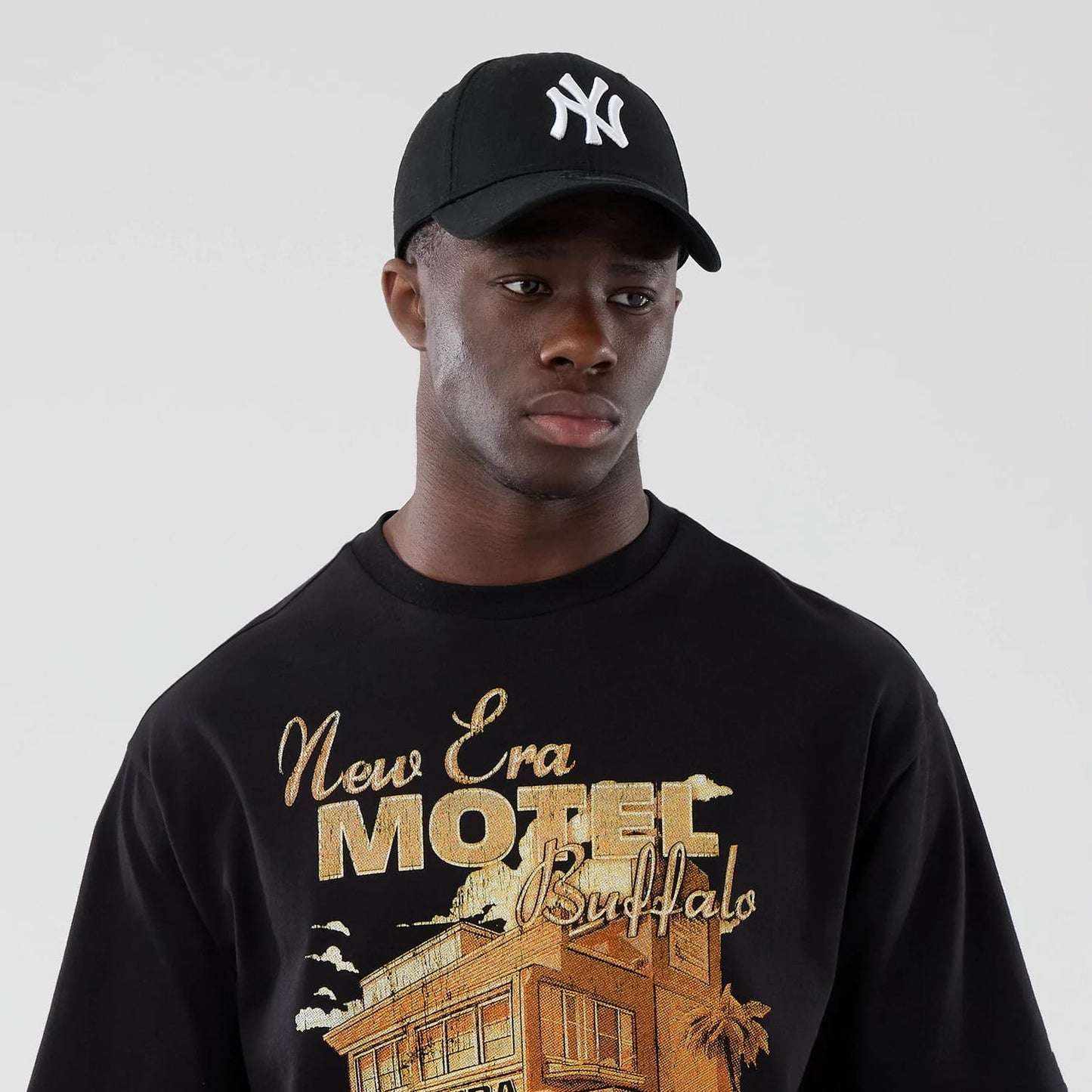 The model is wearing this New Era Motor Graphic Oversized T-Shirt in black. 6
