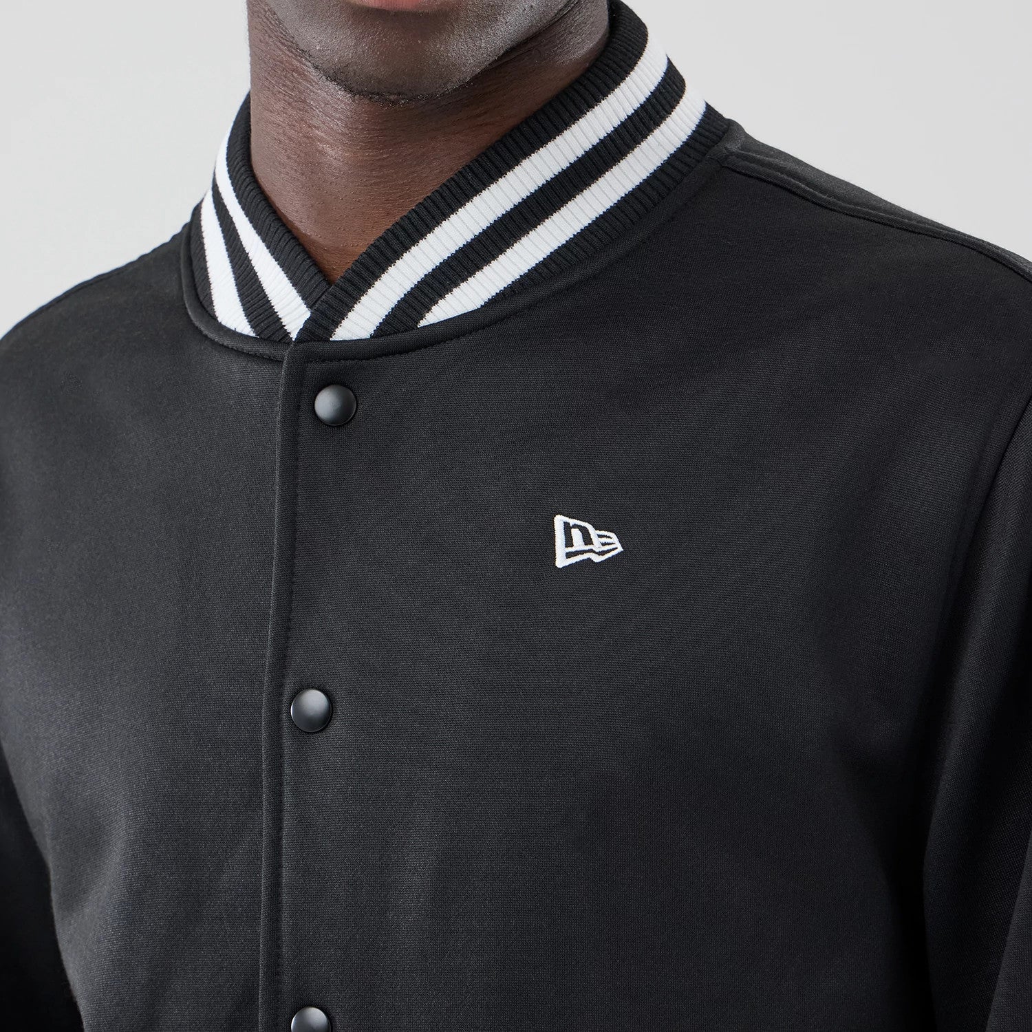 The model is wearing this New Era Jersey Bomber Jacket in black. 4