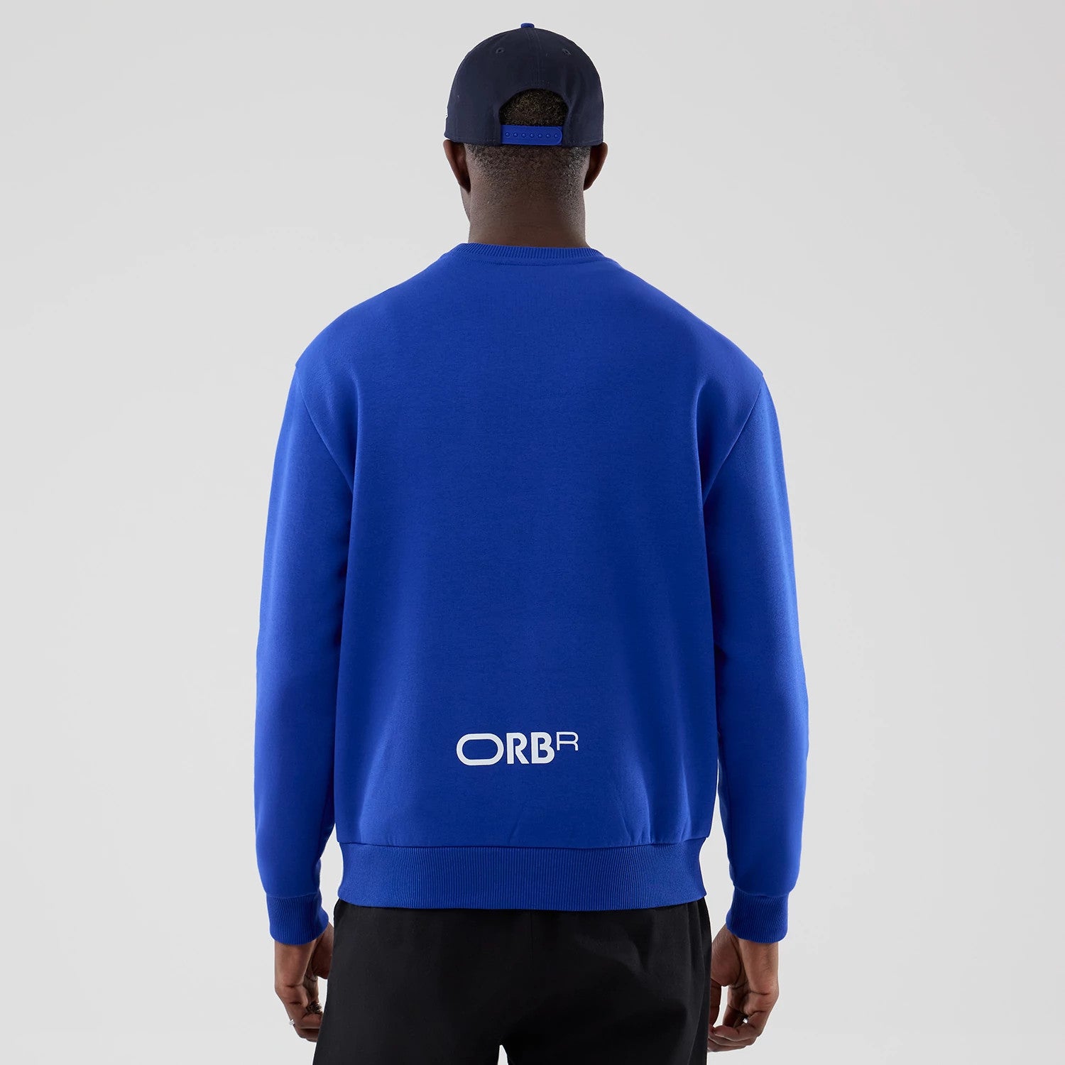 The model is wearing this Red Bull Racing Oversized Crew Neck Sweater in blue. 2