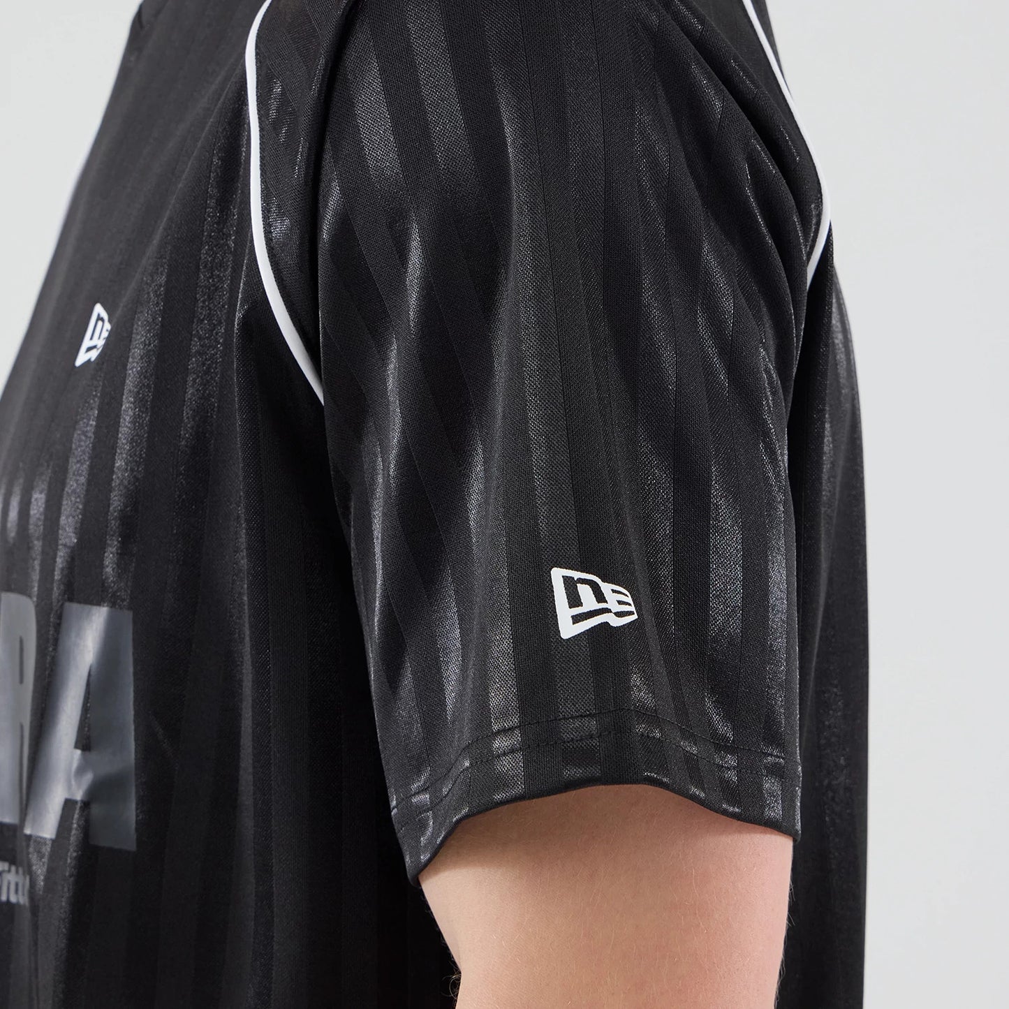 The model is wearing this New Era Football Jersey T-Shirt in black. 5