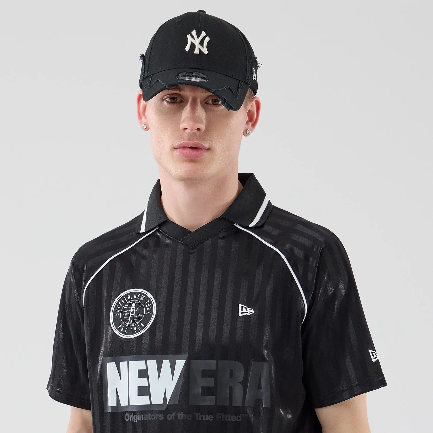 The model is wearing this New Era Football Jersey T-Shirt in black. 6