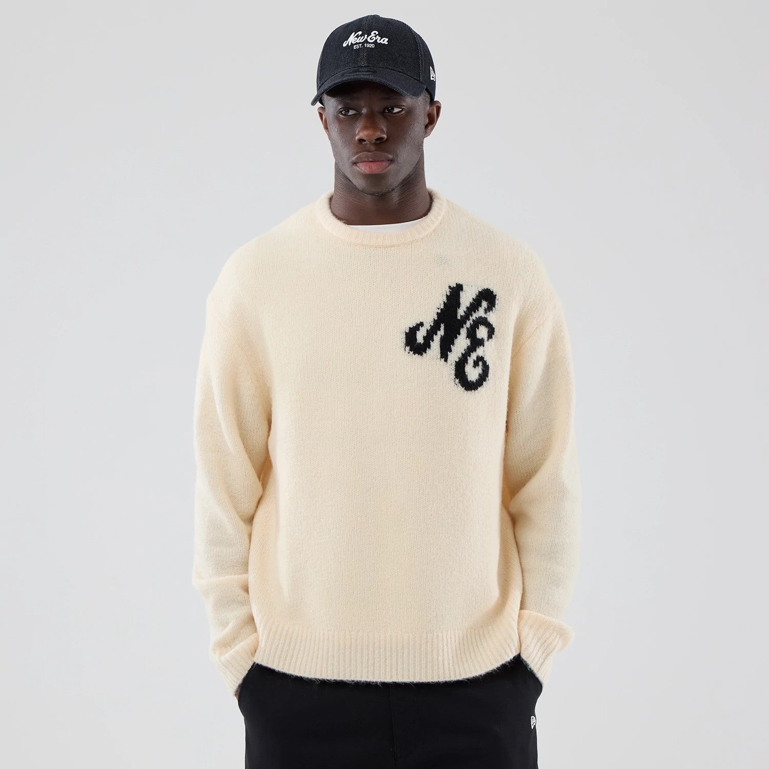 The model is wearing this New Era Knit Knitted Sweater in cream. 3