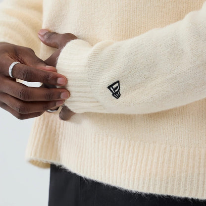 The model is wearing this New Era Knit Knitted Sweater in cream. 7