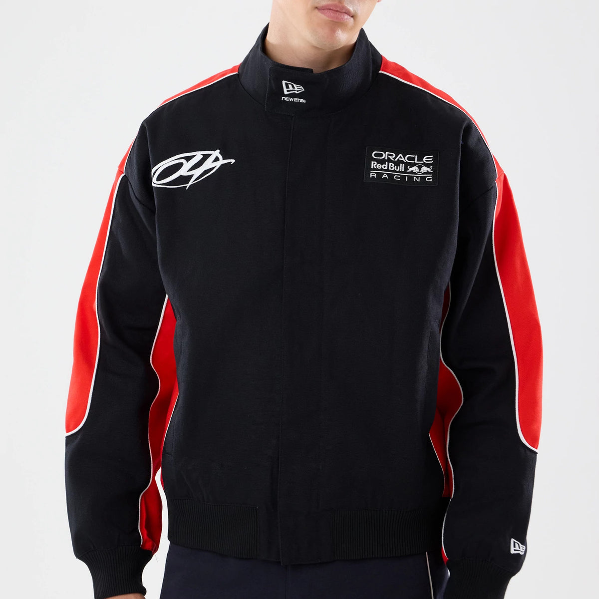 New Era Red Bull Racing Motorsport Black Jacket, front view showing a model wearing the jacket with red panels on each sleeve, a white embroidered logo on the right chest, and a small embroidered New Era logo on the collar.