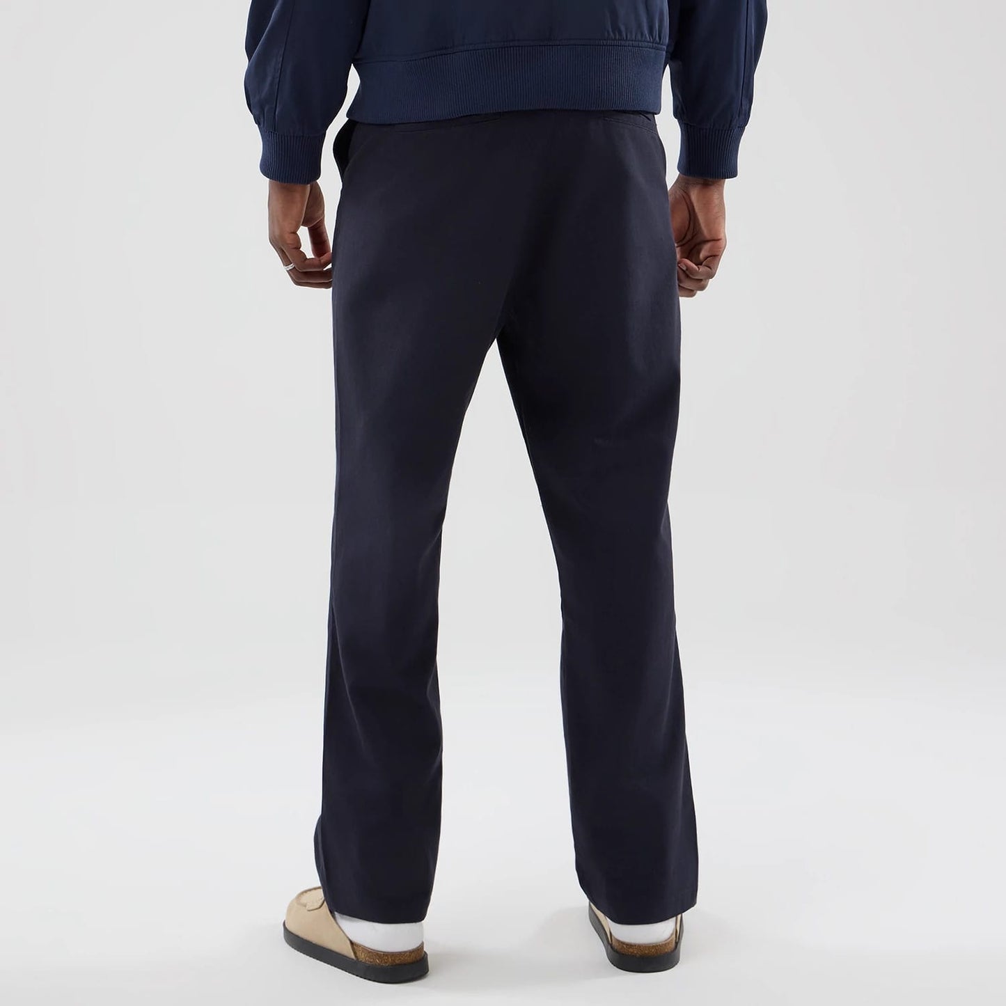 The model is wearing these New Era Chino Trousers in navy. 2