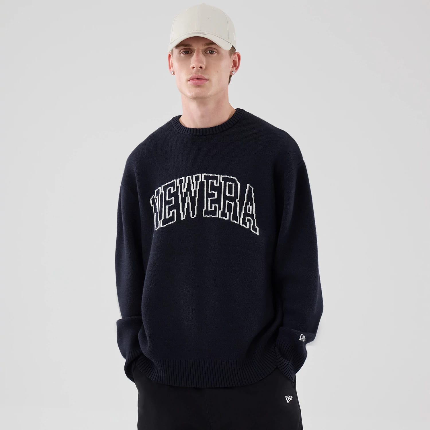 The model is wearing this New Era Knit Knitted Sweater in navy. 3