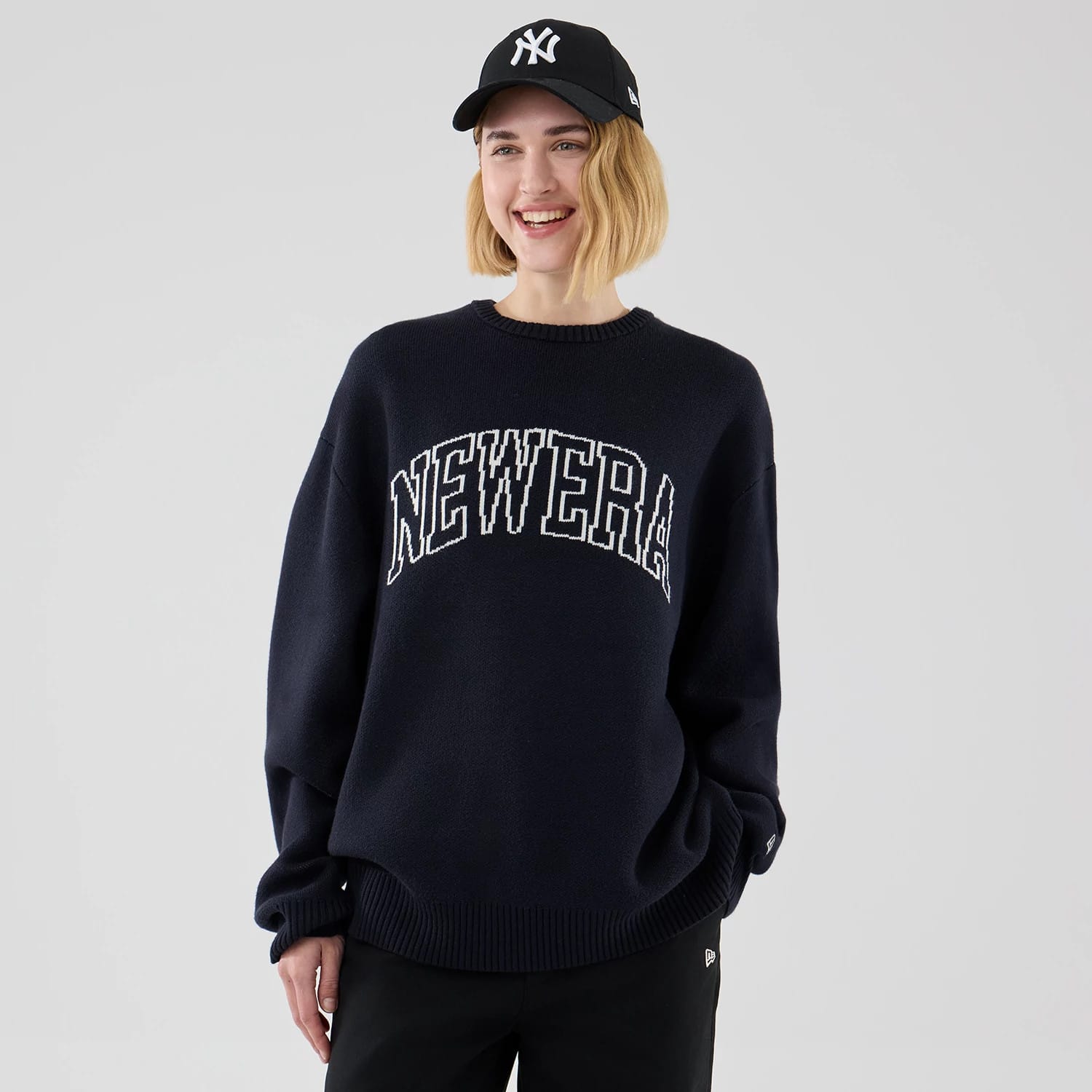 The model is wearing this New Era Knit Knitted Sweater in navy. 4