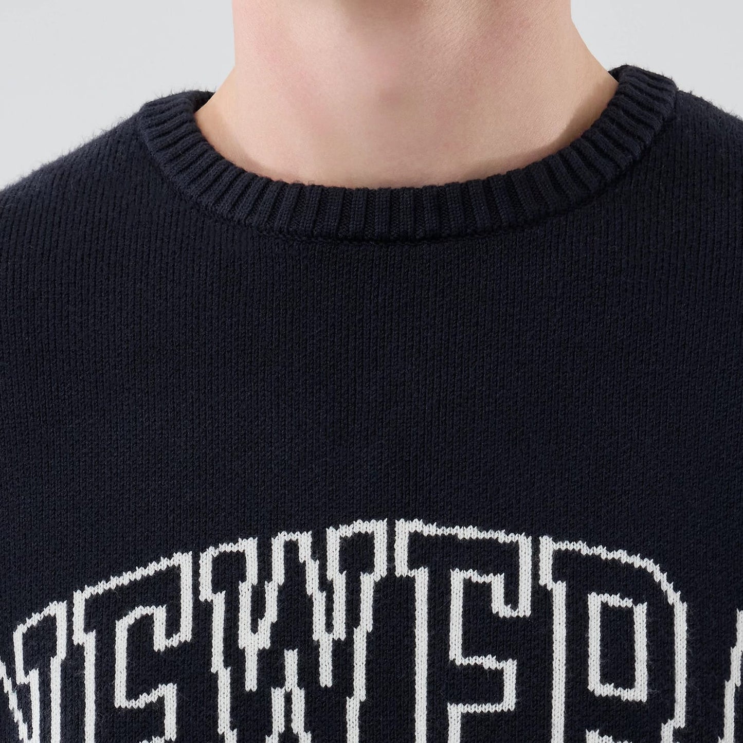 The model is wearing this New Era Knit Knitted Sweater in navy. 5