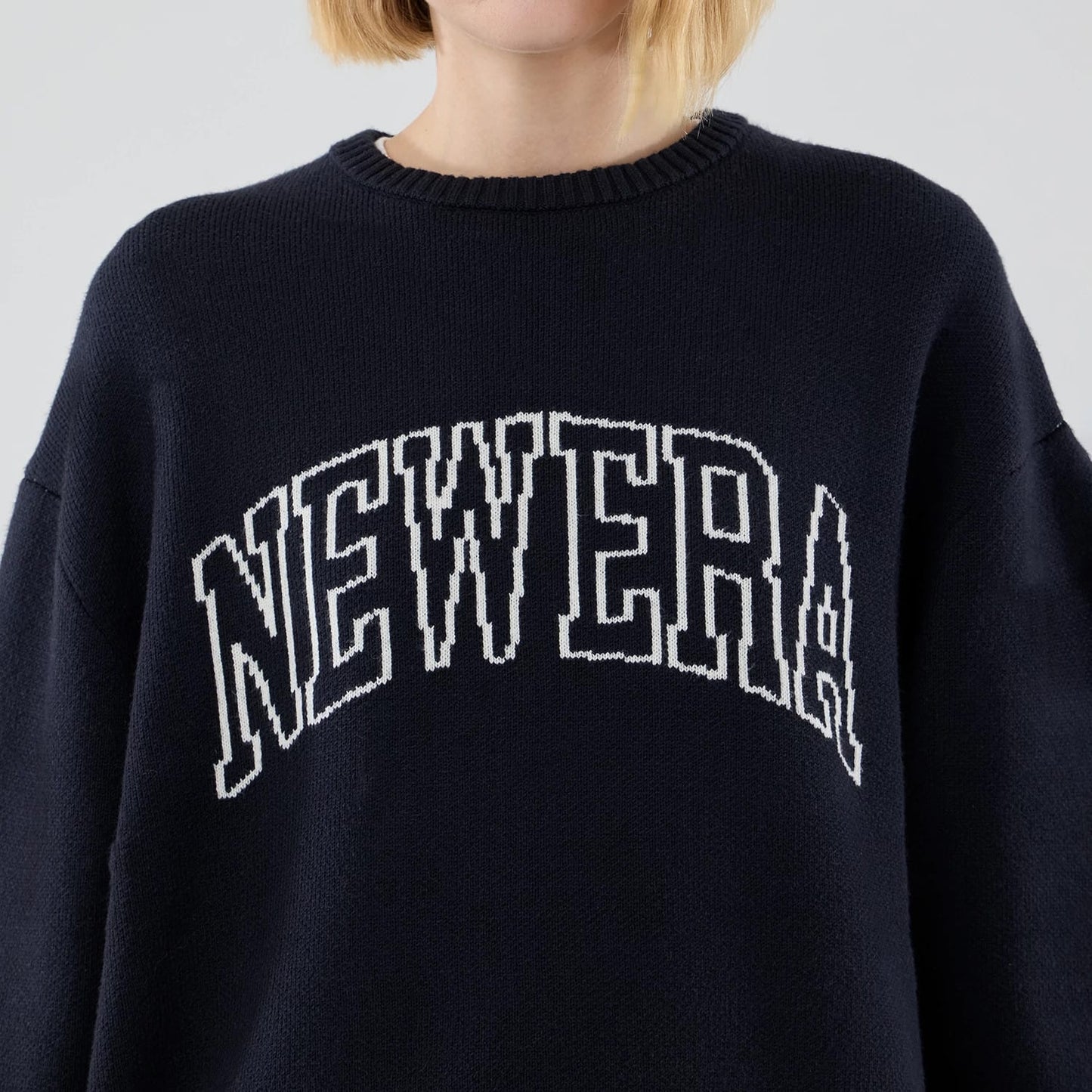 The model is wearing this New Era Knit Knitted Sweater in navy. 6