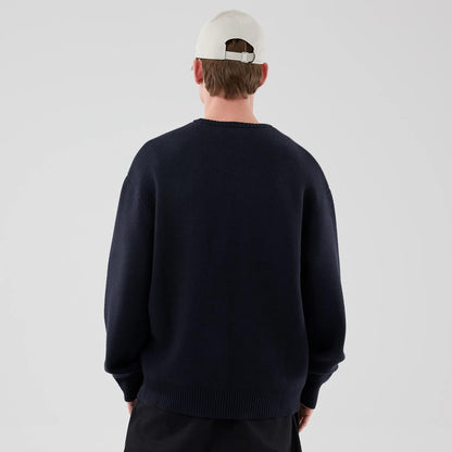 The model is wearing this New Era Knit Knitted Sweater in navy. 2