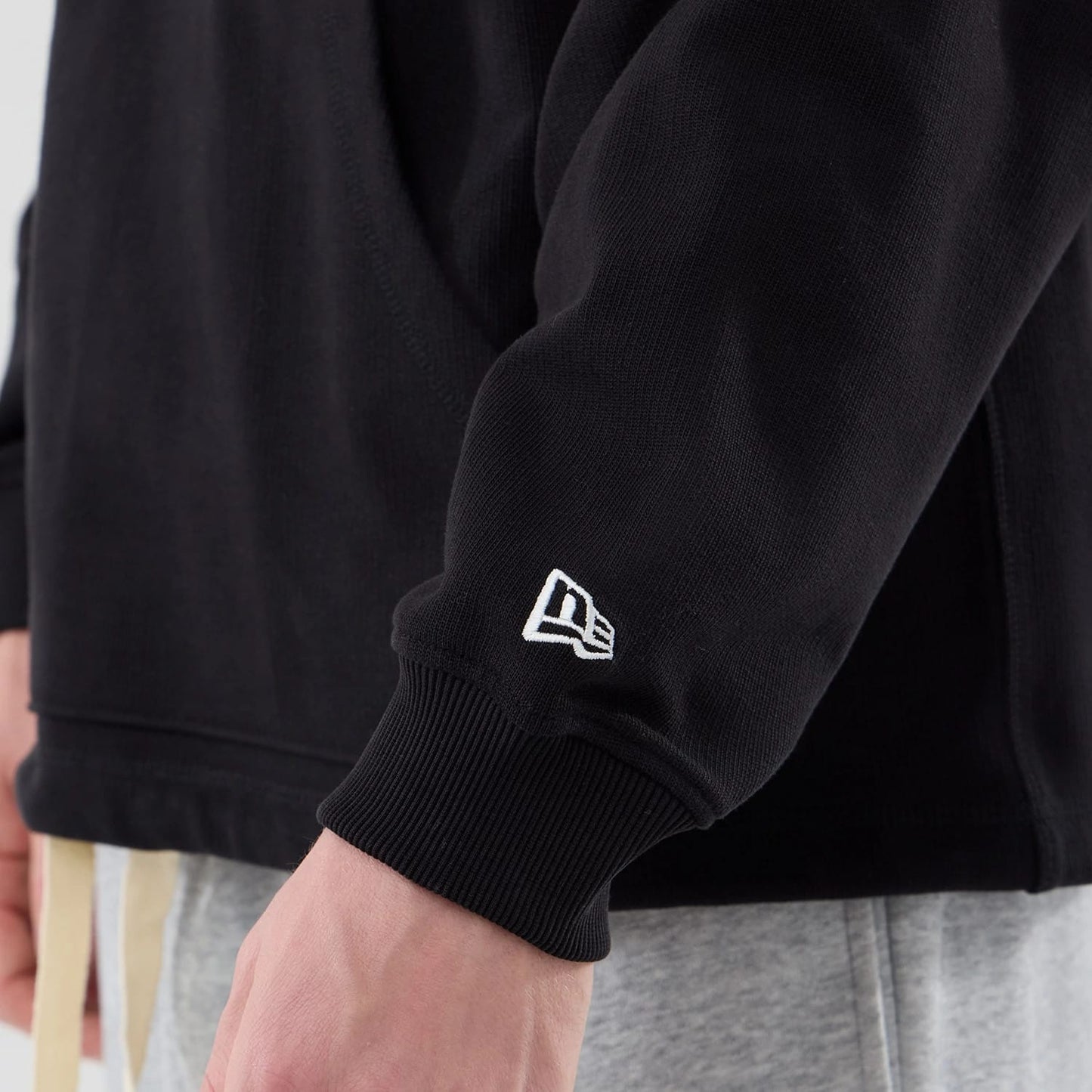 The model is wearing this New Era Open Hem Pullover Hoodie in black. 7