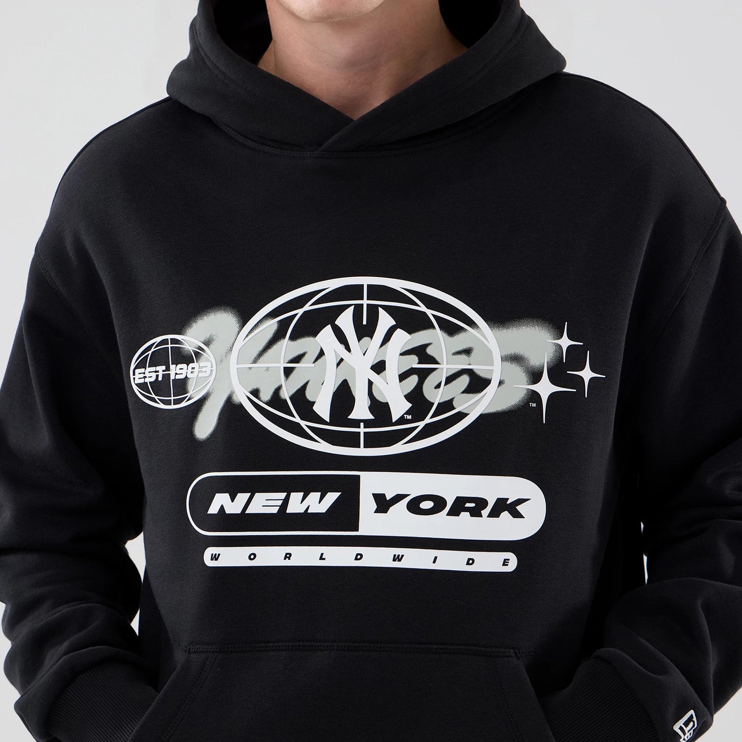 The model is wearing this MLB Logo Graphic New York Yankees Oversized Pullover Hoodie in black. 6