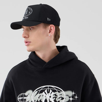 The model is wearing this MLB Logo Graphic New York Yankees Oversized Pullover Hoodie in black. 4