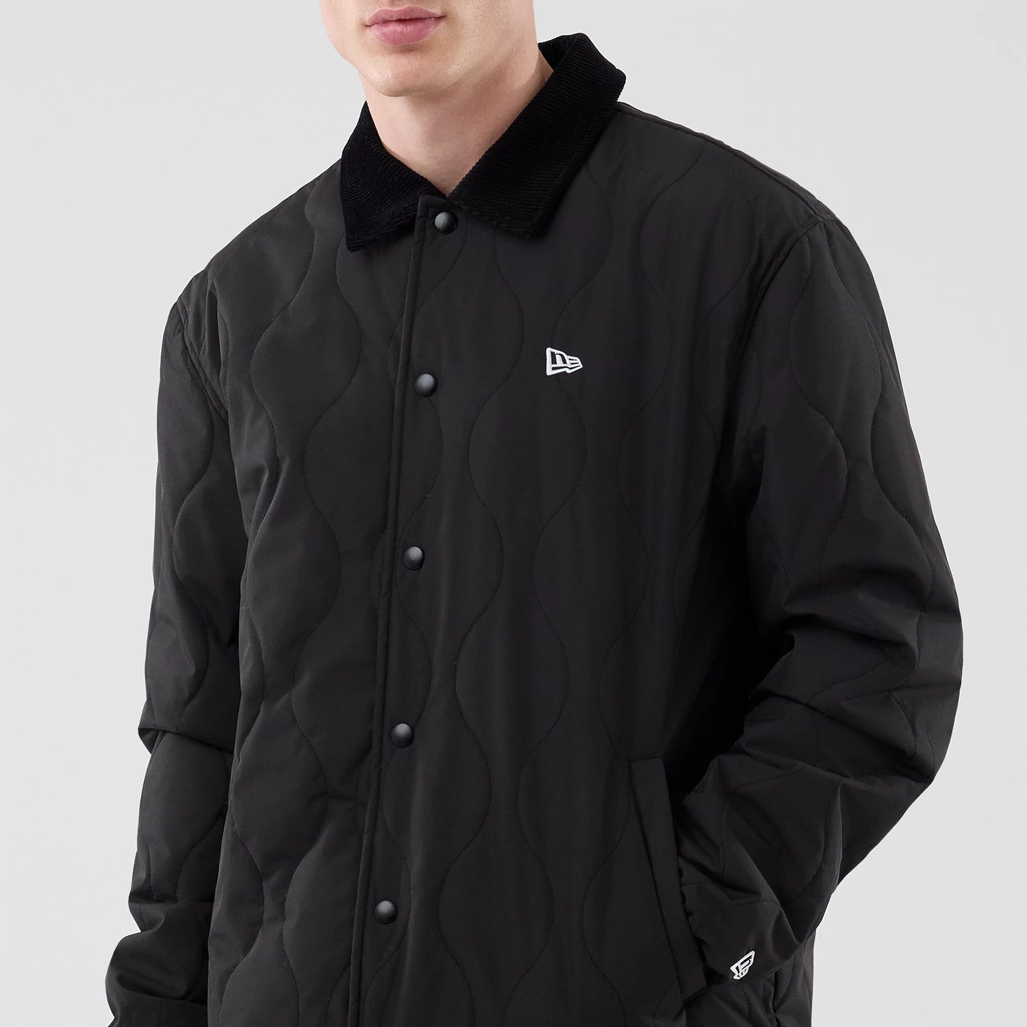 The model is wearing this New Era Quilted Coaches Jacket in black. 3