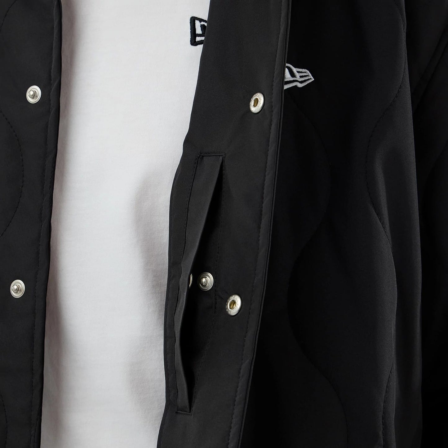 The model is wearing this New Era Quilted Coaches Jacket in black. 6