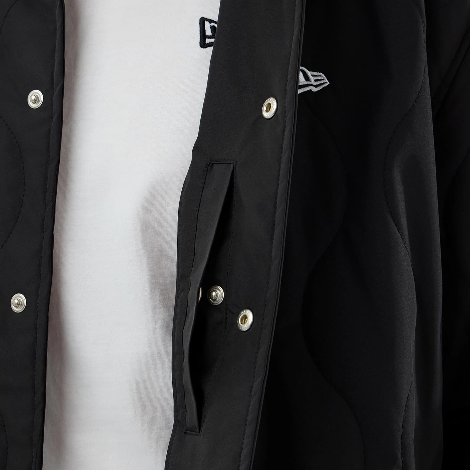 The model is wearing this New Era Quilted Coaches Jacket in black. 6