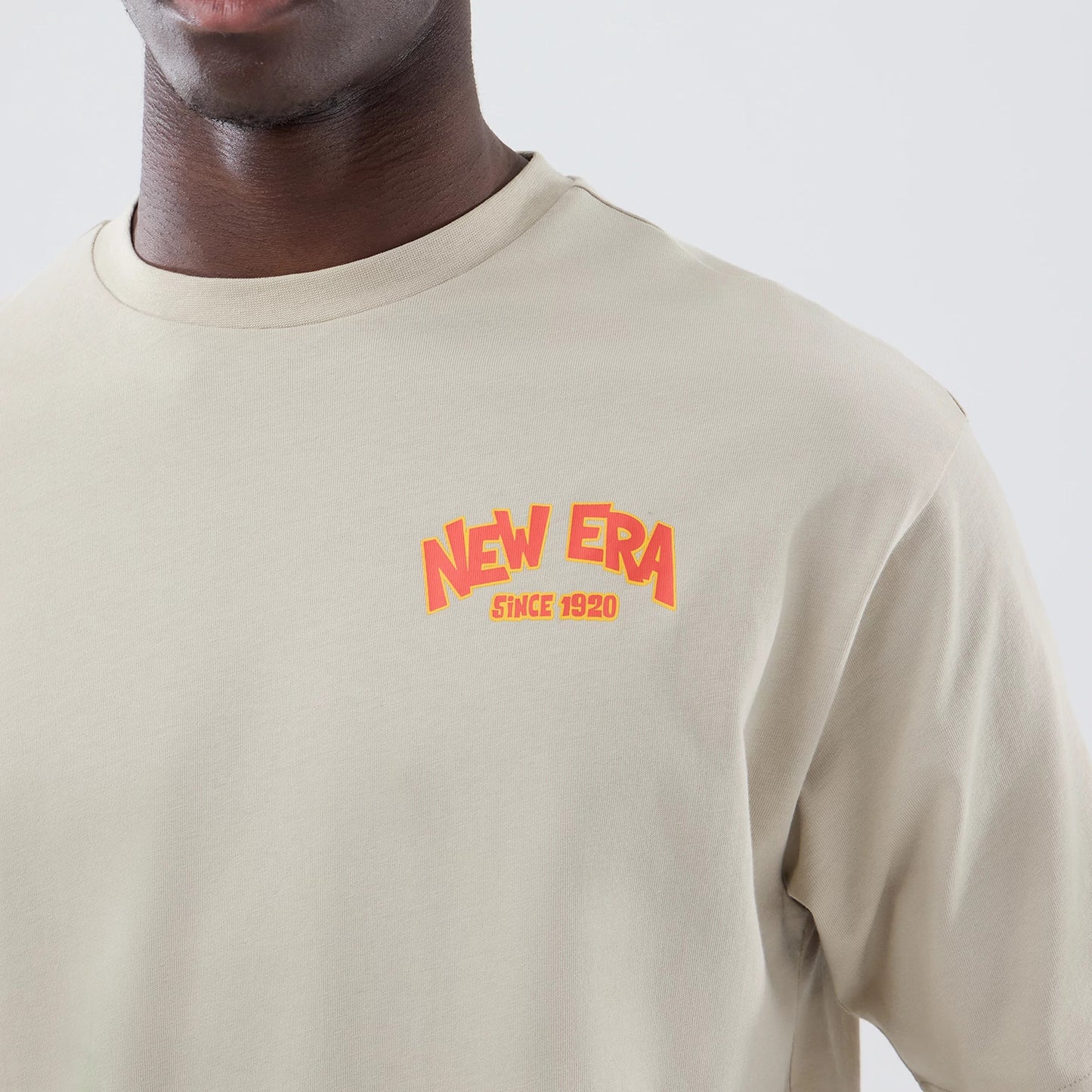 The model is wearing this New Era Food Graphic Oversized T-Shirt in light beige. 5