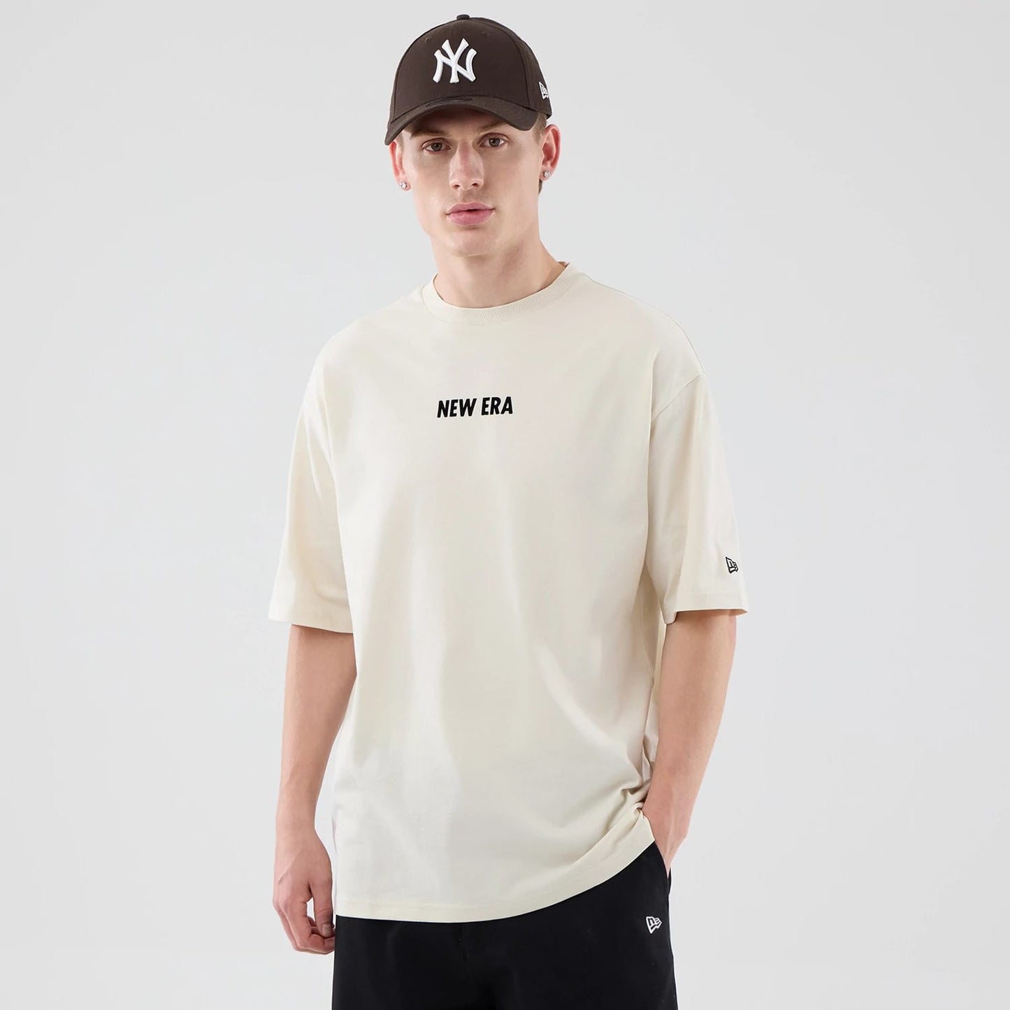 The model is wearing this New Era Cap Graphic Oversized T-Shirt in cream. 3