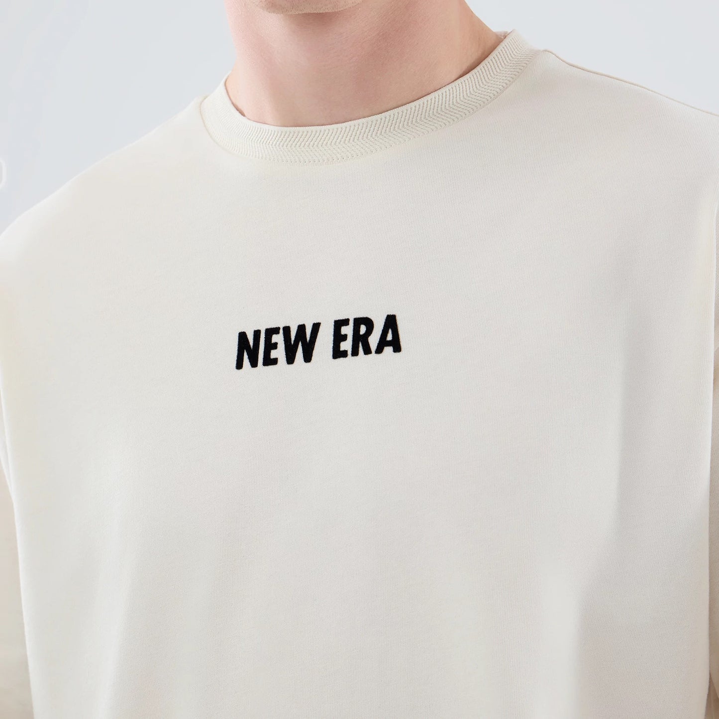The model is wearing this New Era Cap Graphic Oversized T-Shirt in cream. 5