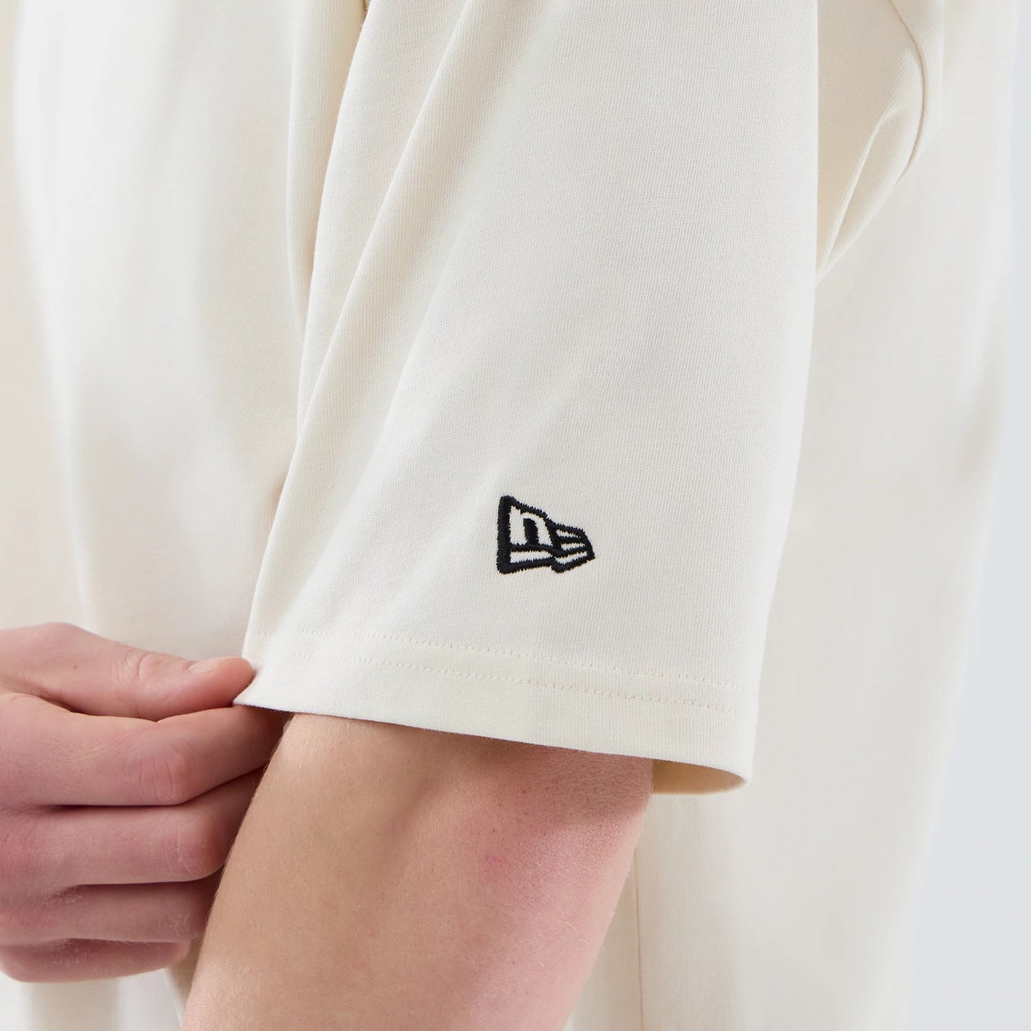 The model is wearing this New Era Cap Graphic Oversized T-Shirt in cream. 7