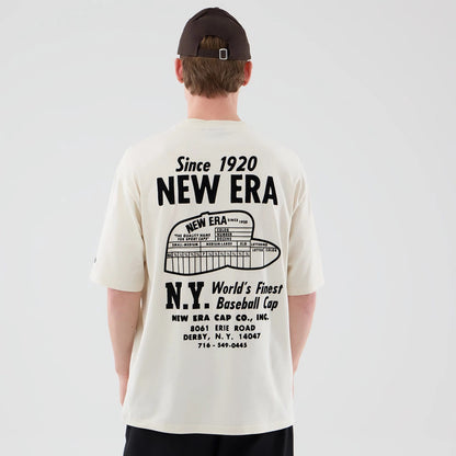 The model is wearing this New Era Cap Graphic Oversized T-Shirt in cream. 2