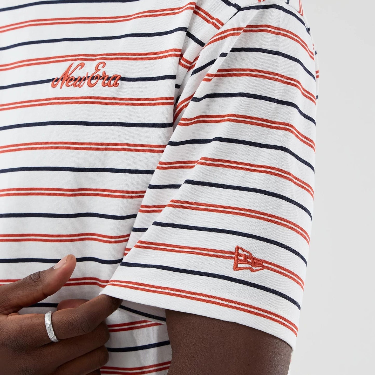 The model is wearing this New Era Stripe Oversized T-Shirt in white. 7