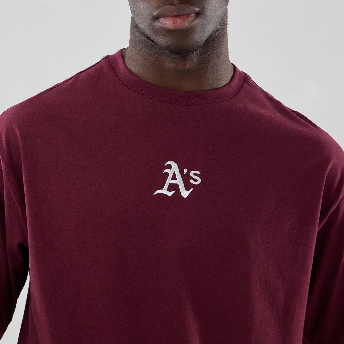 The model is wearing this MLB Midi League Essential Athletics Oversized T-Shirt in dark red. 5