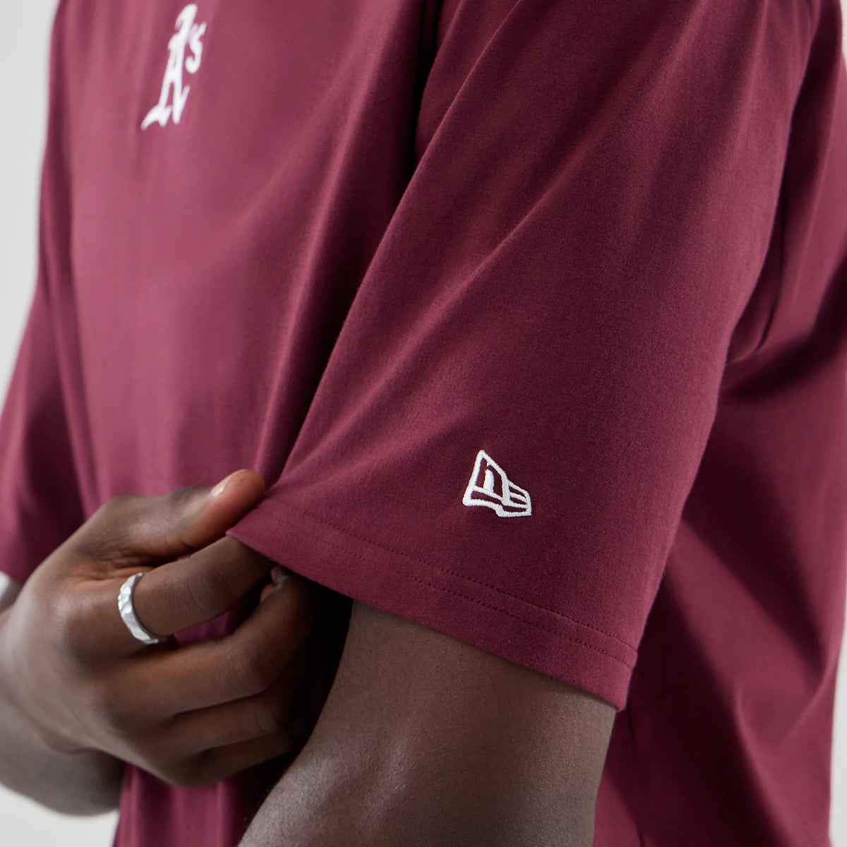 The model is wearing this MLB Midi League Essential Athletics Oversized T-Shirt in dark red. 7