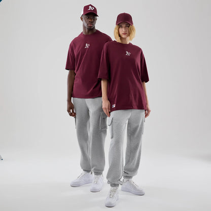 The model is wearing this MLB Midi League Essential Athletics Oversized T-Shirt in dark red. 1