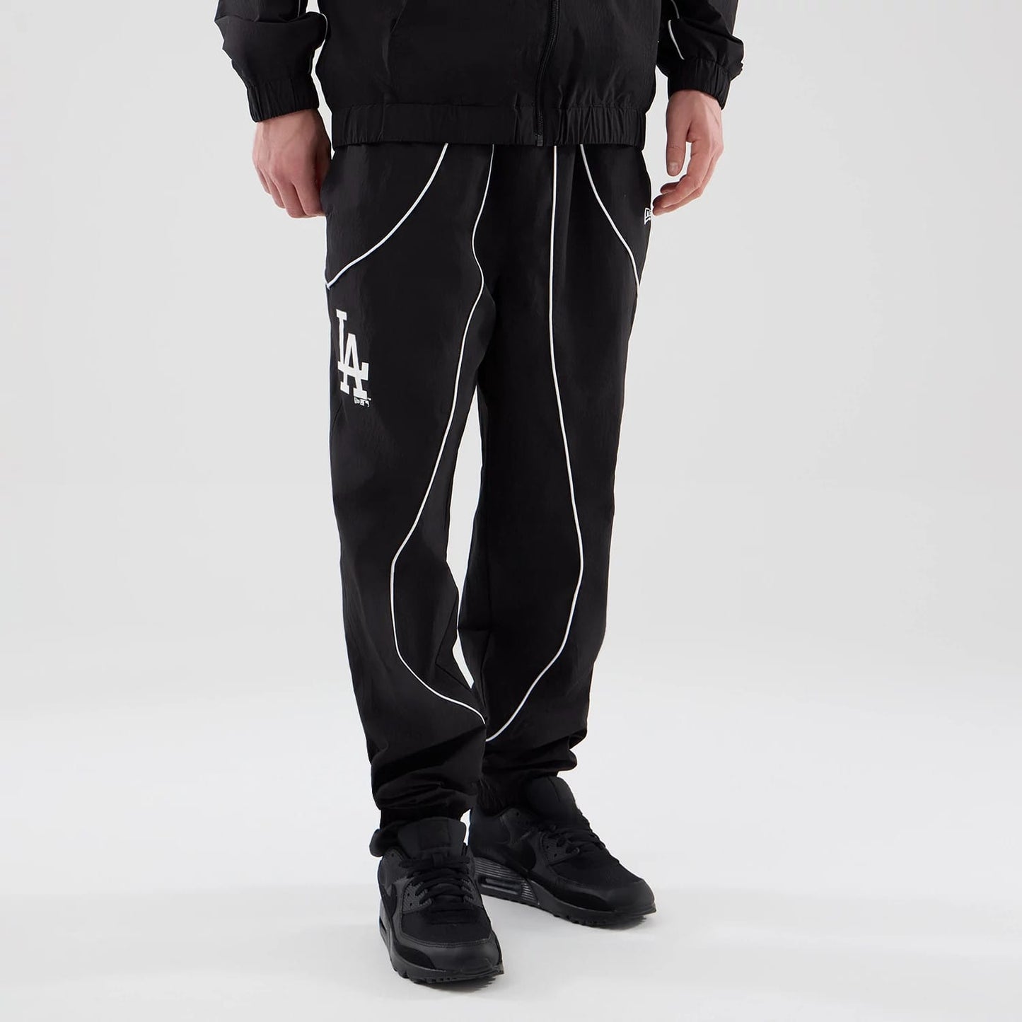 The model is wearing these MLB Piping Track LA Dodgers Track Pants in black. 3