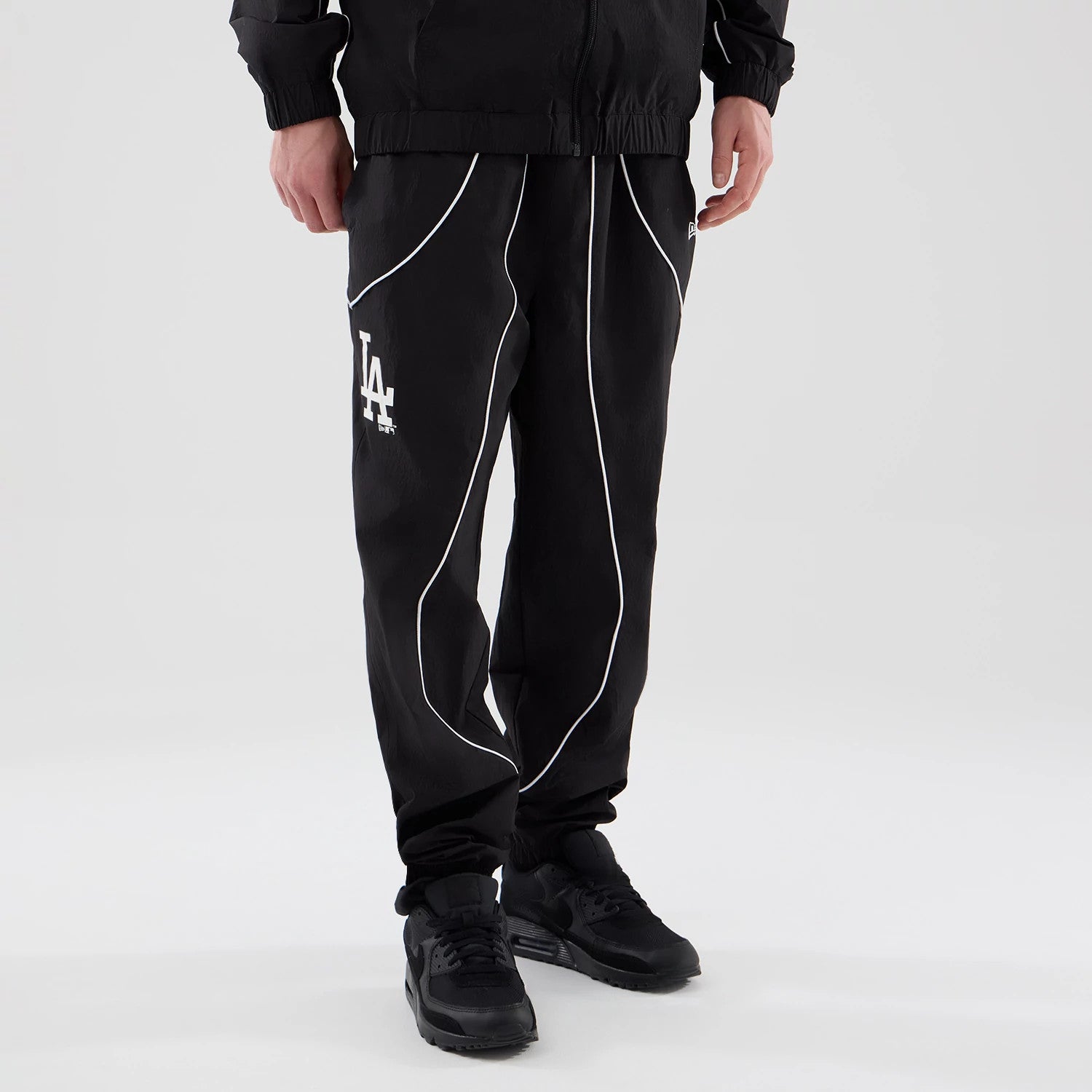 The model is wearing these MLB Piping Track LA Dodgers Track Pants in black. 3