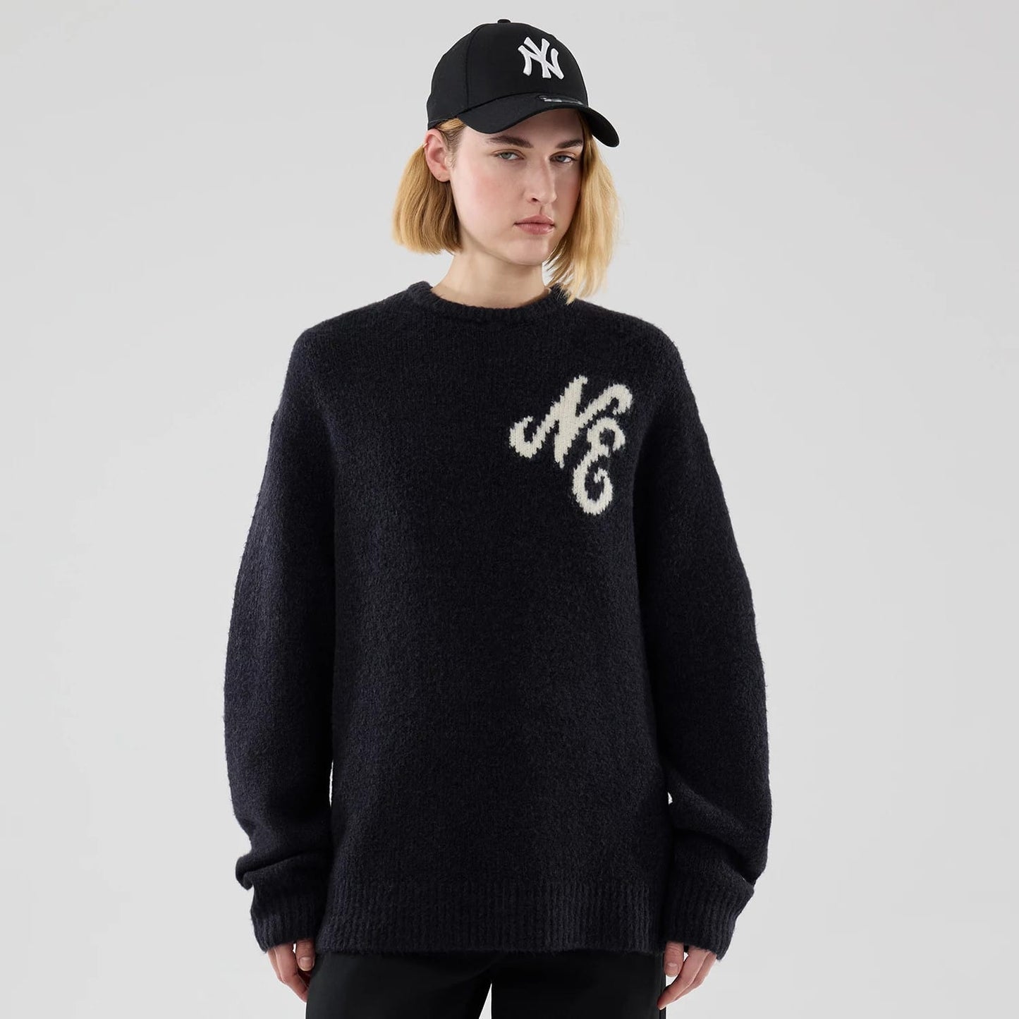The model is wearing this New Era Knit Knitted Sweater in navy. 4