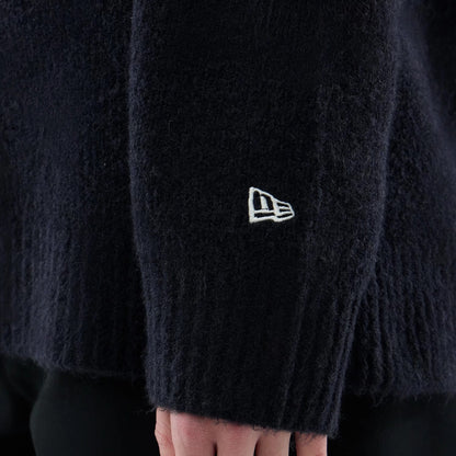 The model is wearing this New Era Knit Heritage Knitted Sweater in navy. 7