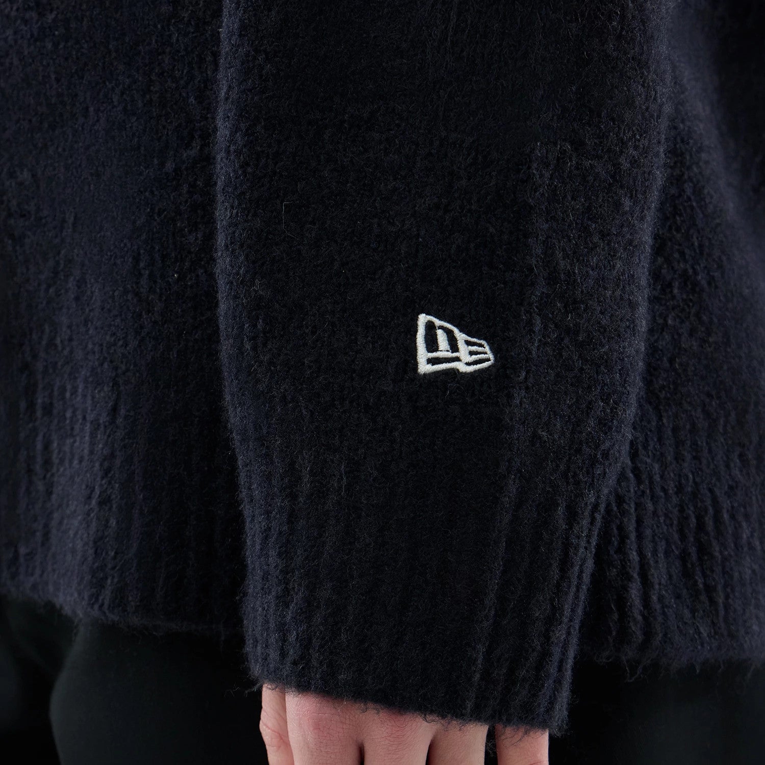 The model is wearing this New Era Knit Heritage Knitted Sweater in navy. 7