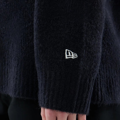 The model is wearing this New Era Knit Heritage Knitted Sweater in navy. 7