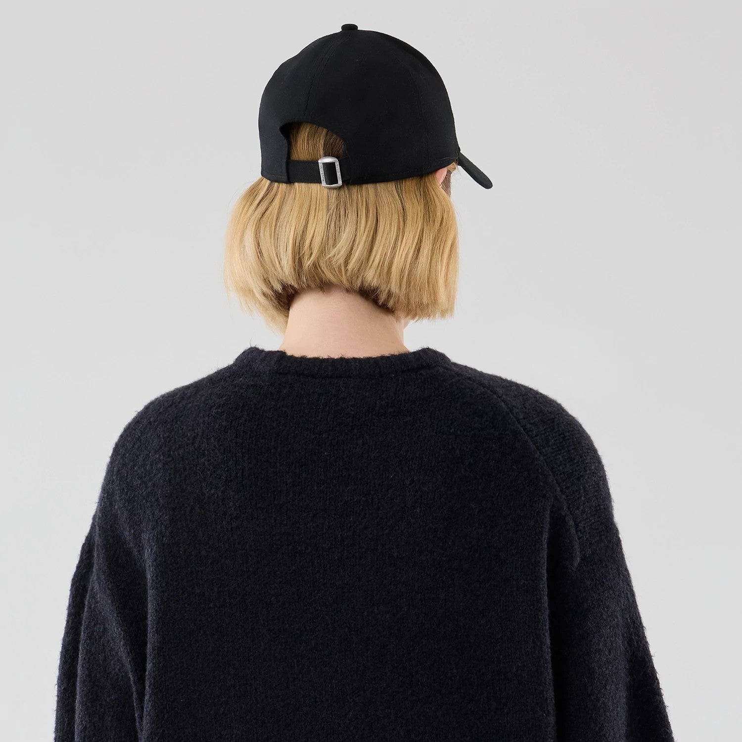 The model is wearing this New Era Knit Heritage Knitted Sweater in navy. 8