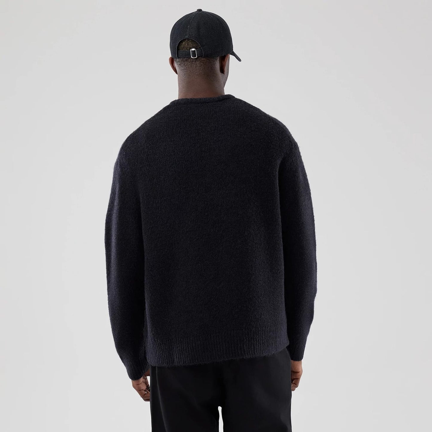 The model is wearing this New Era Knit Knitted Sweater in navy. 2