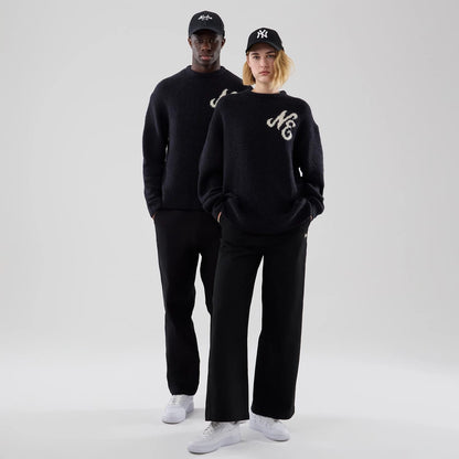 The model is wearing this New Era Knit Knitted Sweater in navy. 1