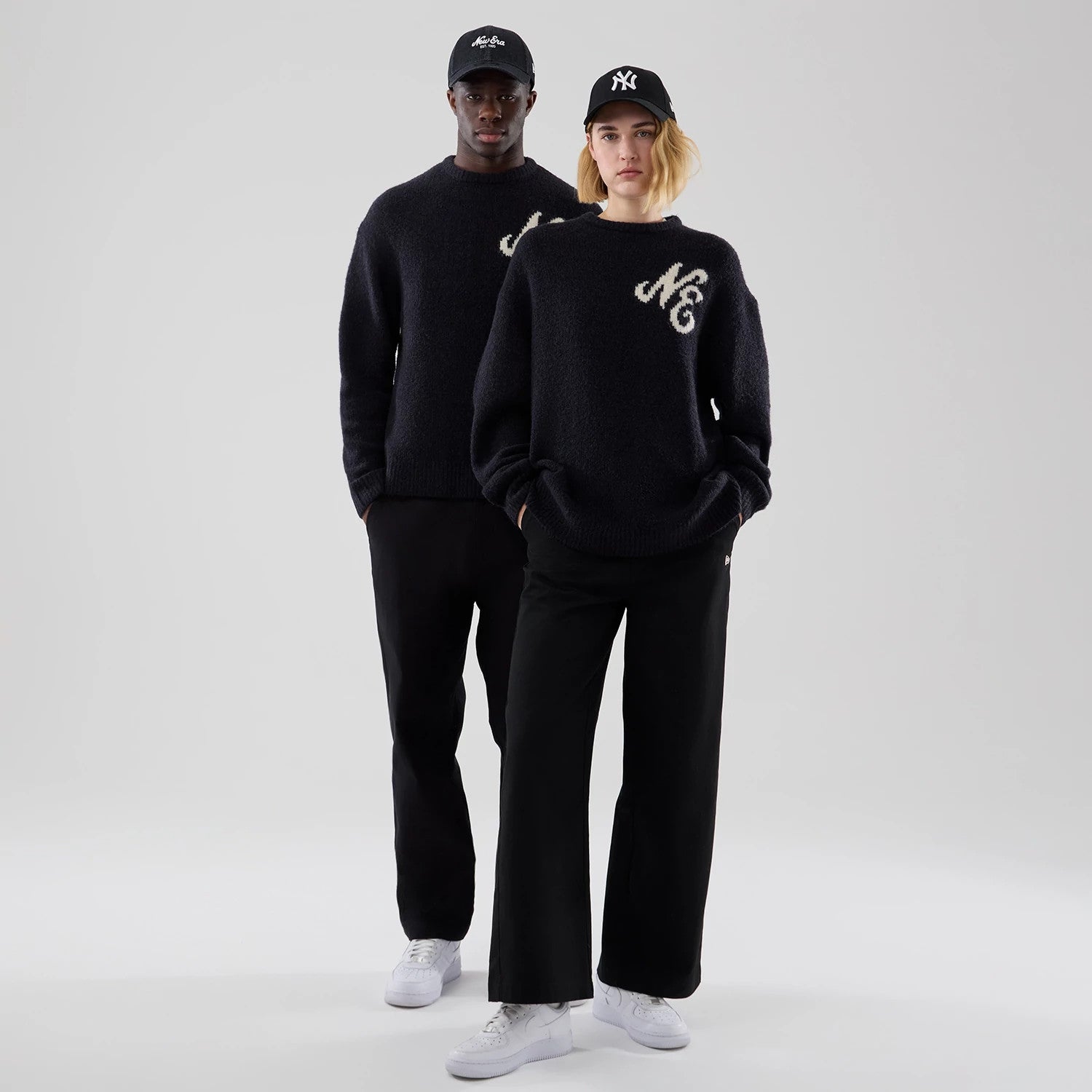 The model is wearing this New Era Knit Heritage Knitted Sweater in navy. 1