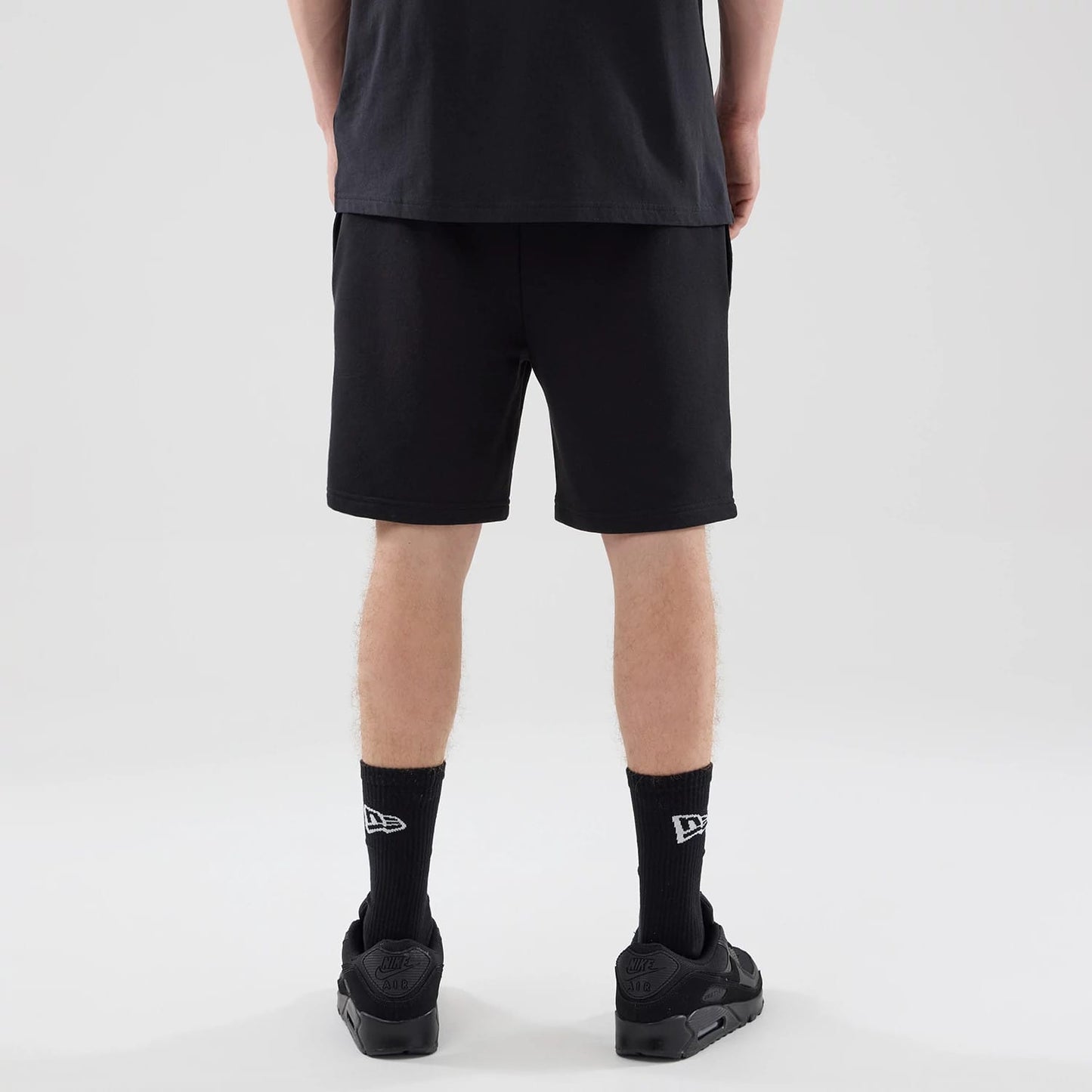 The model is wearing these NBA League Essential Chicago Bulls Oversized Shorts in black. 2