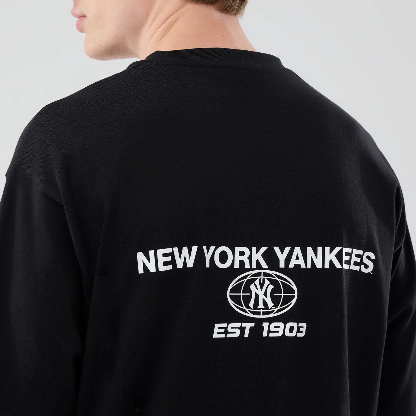 The model is wearing this MLB Logo Graphic New York Yankees Oversized T-Shirt in black. 5