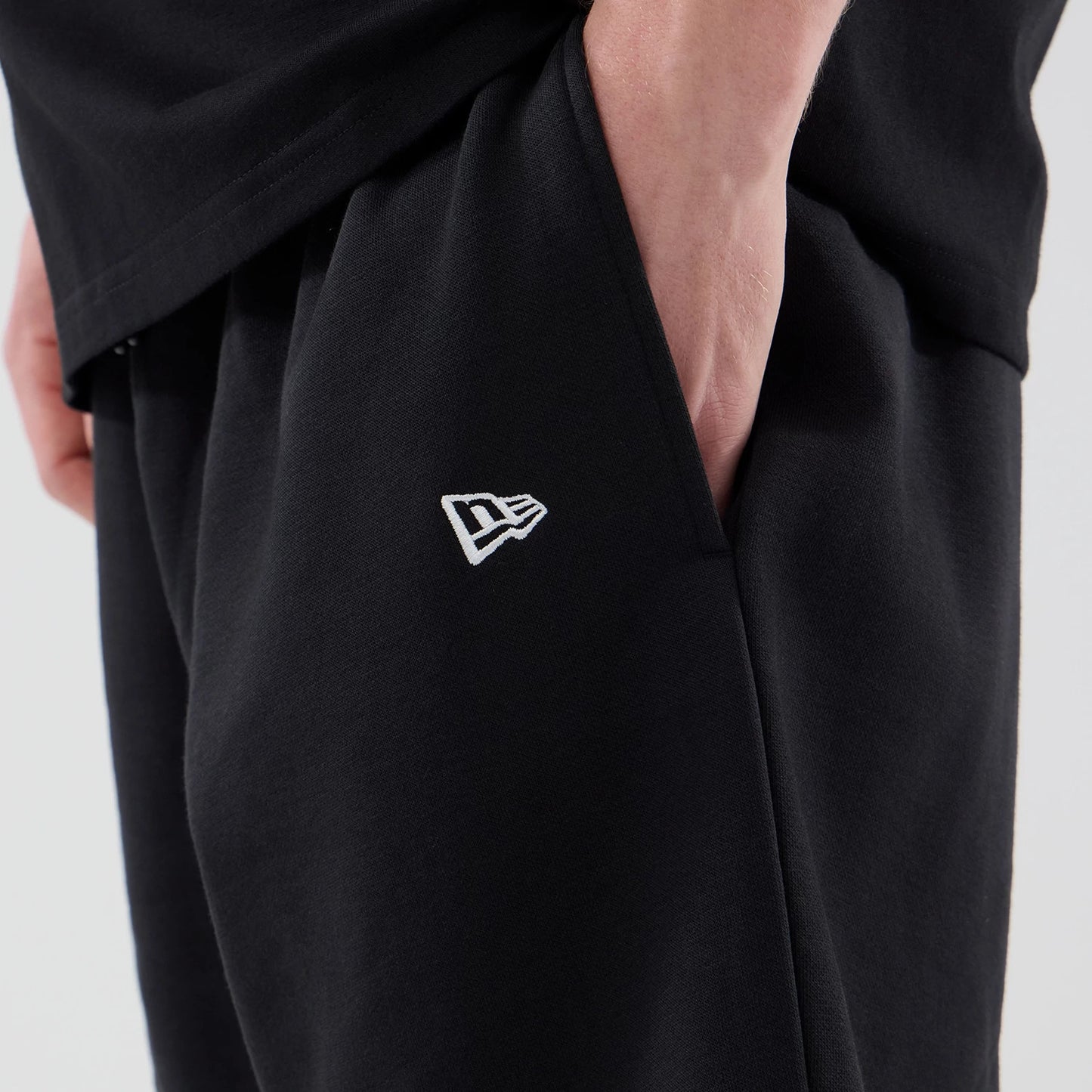 The model is wearing these MLB Logo Graphic New York Yankees Oversized Shorts in black. 5