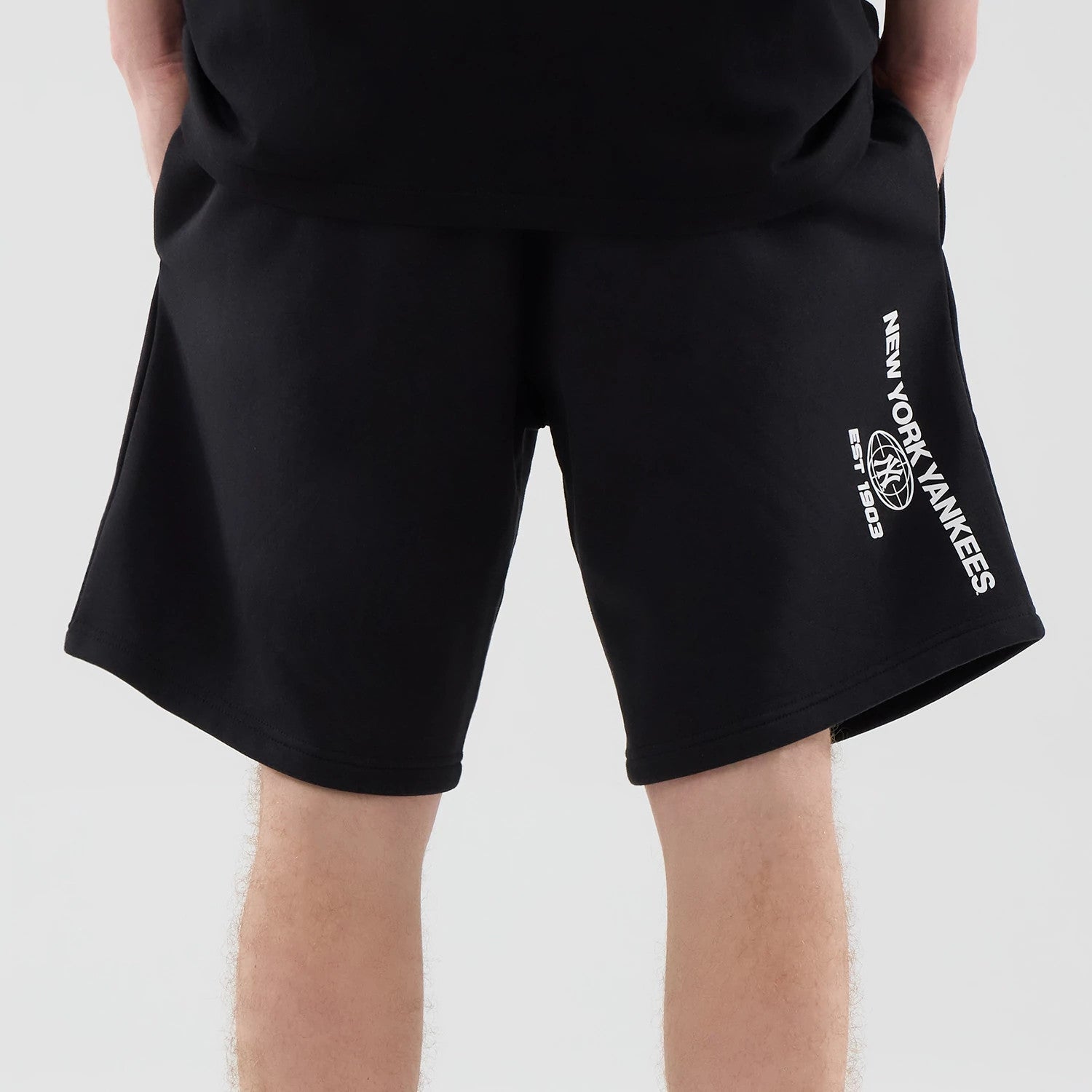 The model is wearing these MLB Logo Graphic New York Yankees Oversized Shorts in black. 7