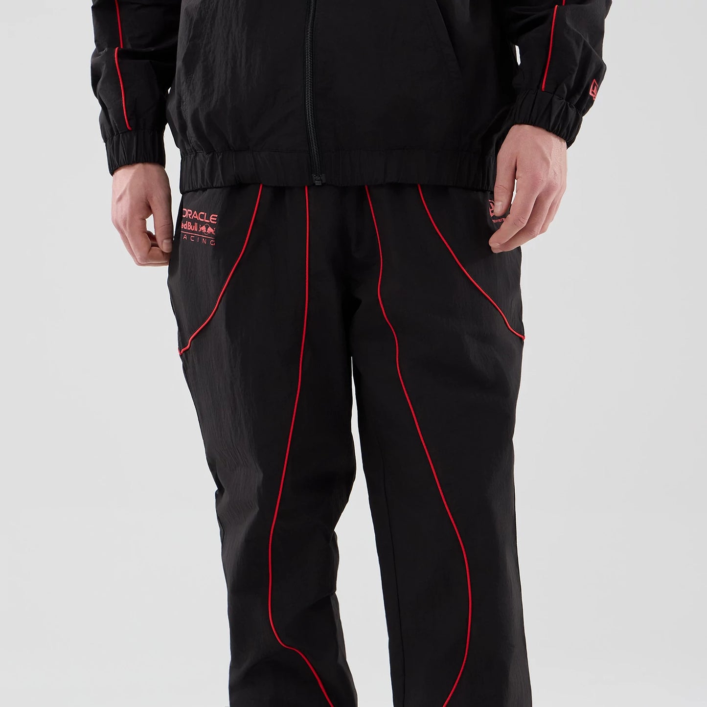 The model is wearing these Red Bull Racing Piping Track Pants in black. 4